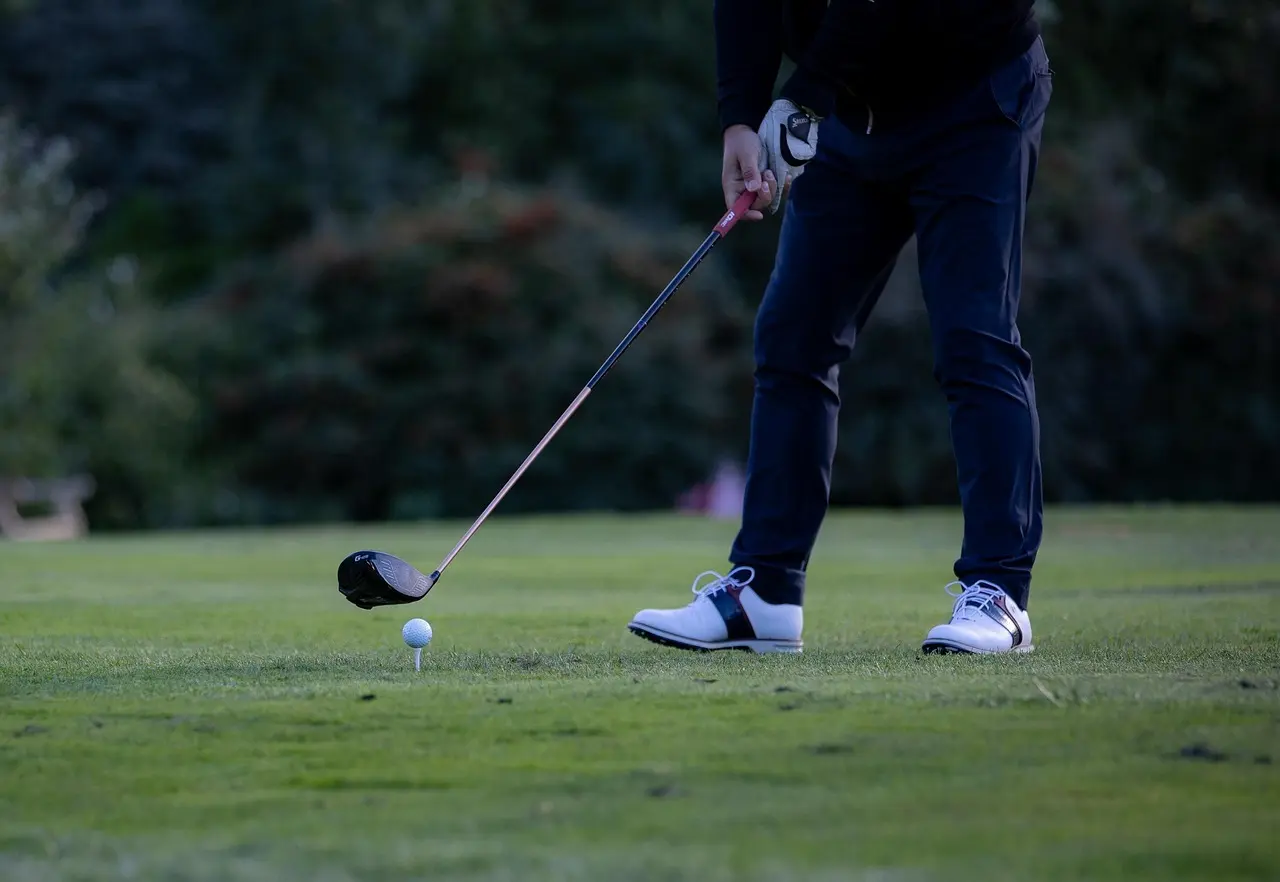 Golfspiller på teeboks med driver og golfbold på tee